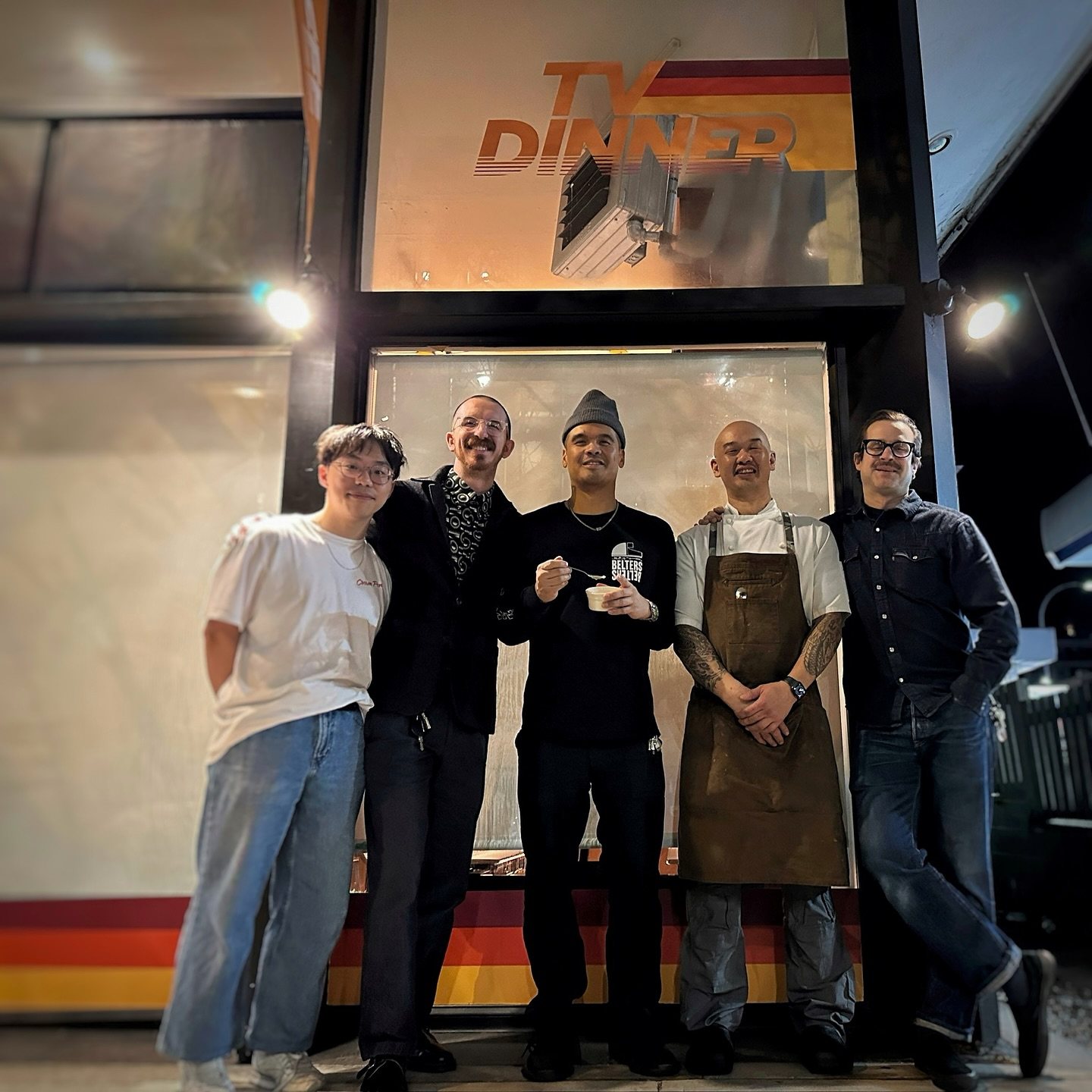 The TV Dinner crew under the lit sign